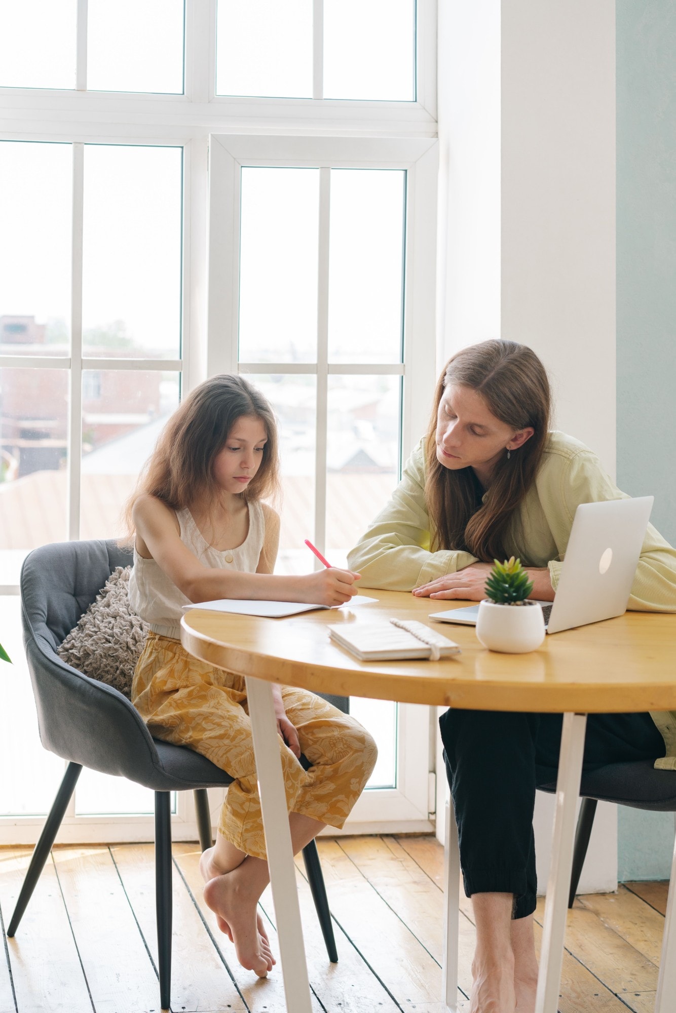 A parent and teenager looking at a laptop together